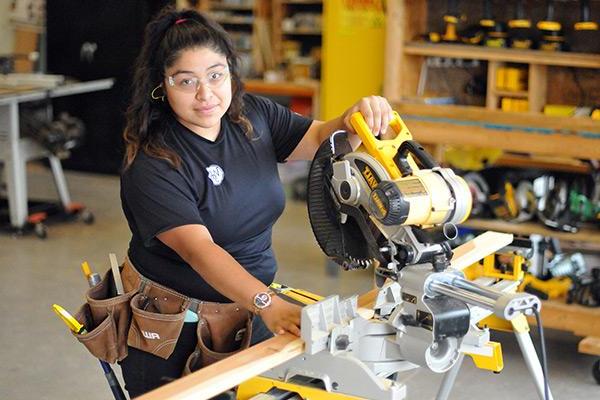 Building Construction student using miter saw